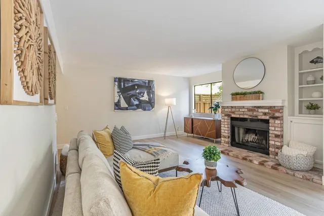 a living room with furniture a fireplace and a table