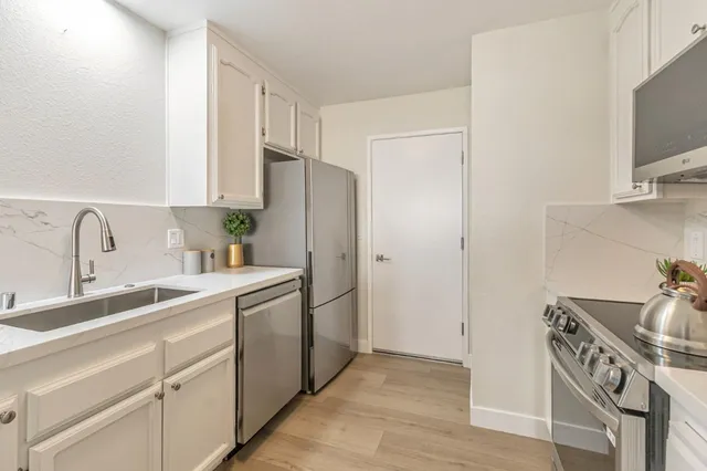 a kitchen with stainless steel appliances a sink stove and refrigerator