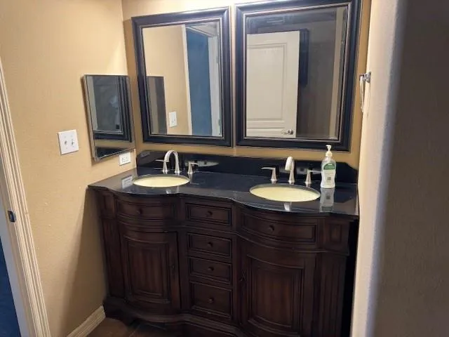a bathroom with a double vanity sink and a mirror