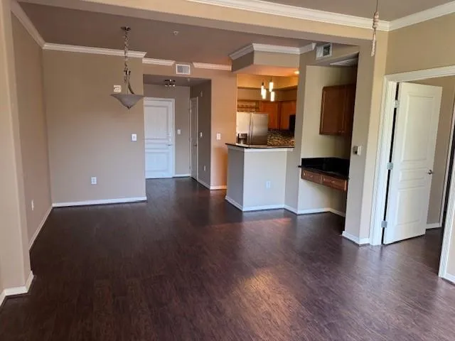a view of a hallway with wooden floor and a cabinet