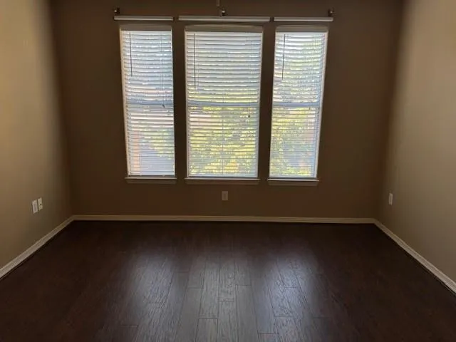 an empty room with wooden floor and a window
