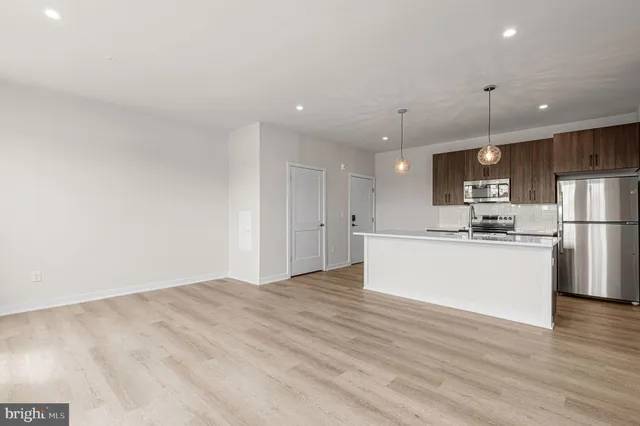 a view of kitchen with stainless steel appliances refrigerator stove microwave and cabinets