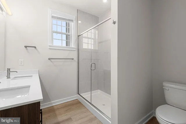 a bathroom with a sink a toilet and shower