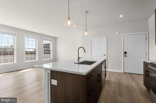 a kitchen that has a sink a window and wooden floor