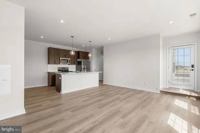 a view of kitchen with microwave oven a sink and dishwasher with wooden floor