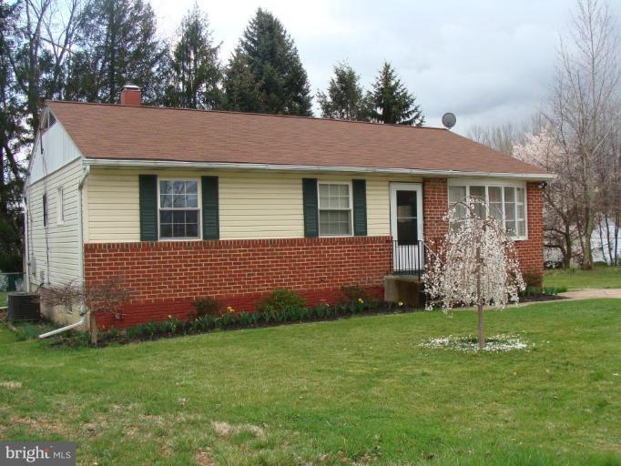 a front view of house with yard and green space