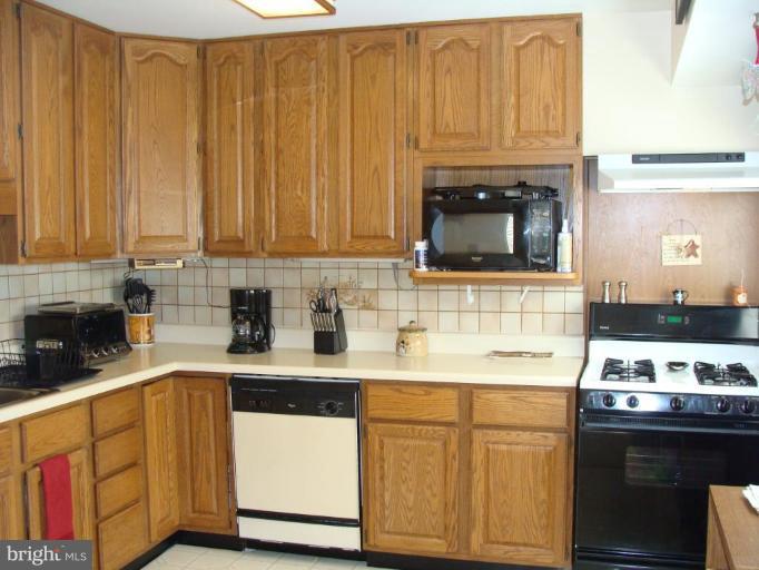 307 Bryanstone Road Reisterstown, MD 21136 - Photo 6 of 25 a kitchen with stainless steel appliances granite countertop a sink stove and cabinets