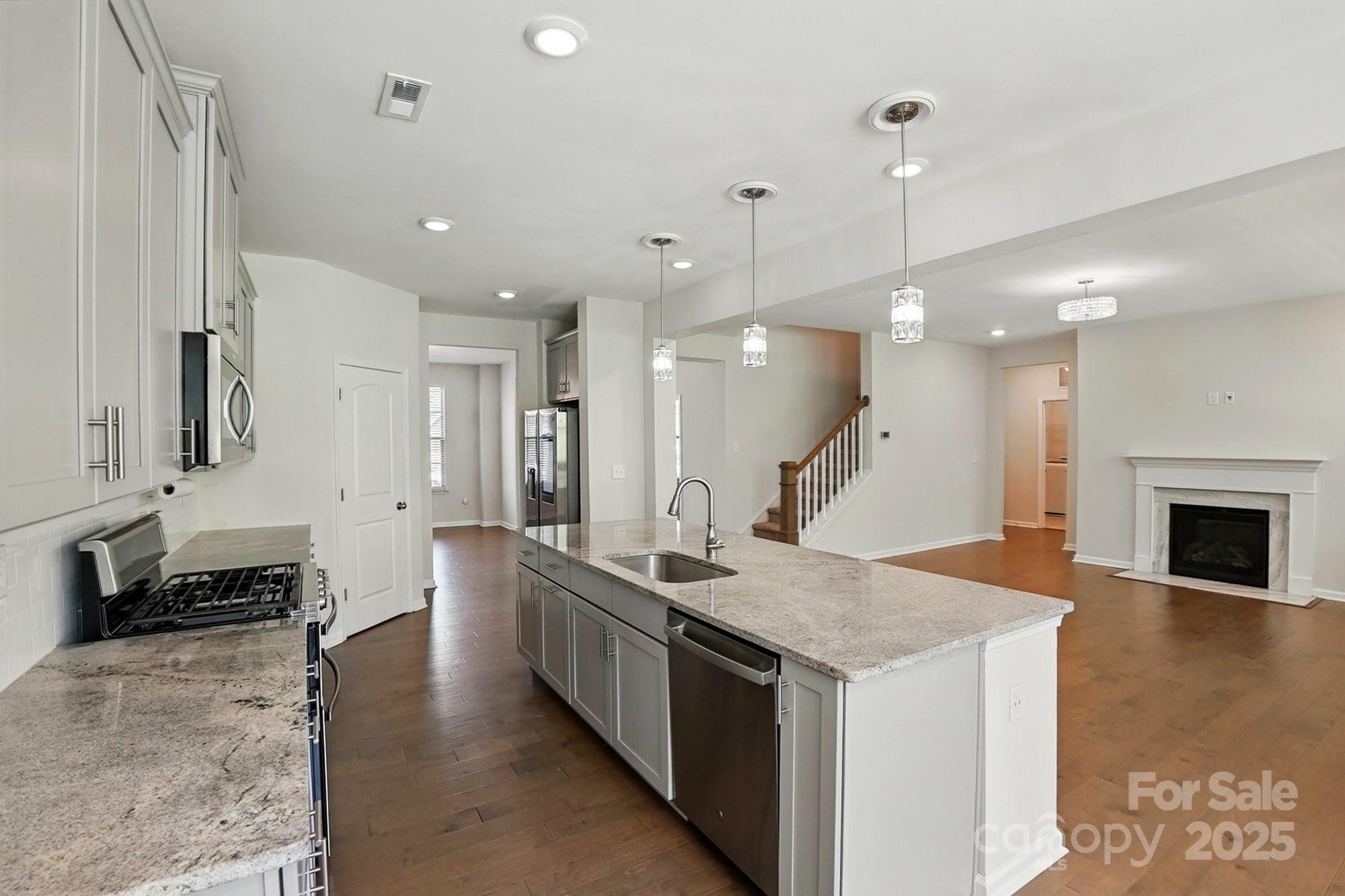 20422 Creek Bend Edge Court Matthews, NC 28105 - Photo 8 of 39 a large kitchen with granite countertop a large center island a sink stainless steel appliances and cabinets
