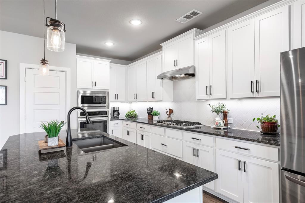 905 Bent Brook Road Little Elm, TX 75068 - Photo 1 of 40 a kitchen with stainless steel appliances kitchen island granite countertop a sink a stove and cabinets