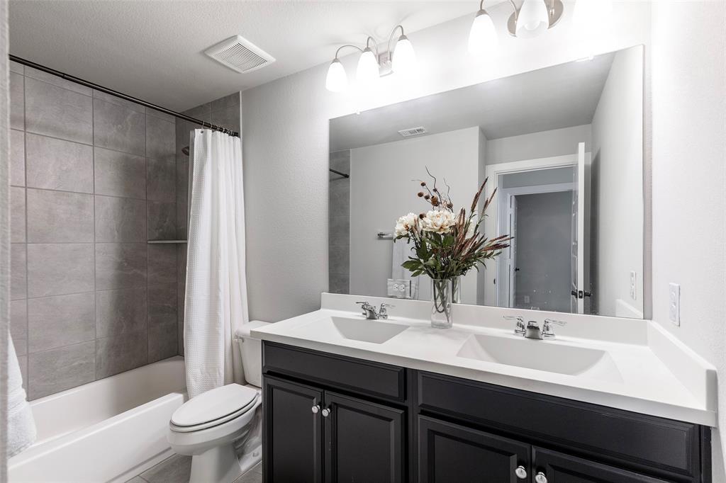 905 Bent Brook Road Little Elm, TX 75068 - Photo 28 of 40 a bathroom with a double vanity sink toilet and shower