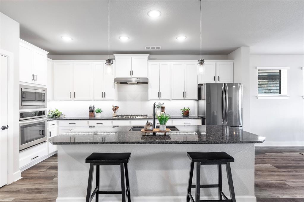 905 Bent Brook Road Little Elm, TX 75068 - Photo 10 of 40 a kitchen with stainless steel appliances a dining table chairs refrigerator and sink