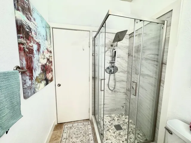 a bathroom with a granite countertop sink toilet and shower