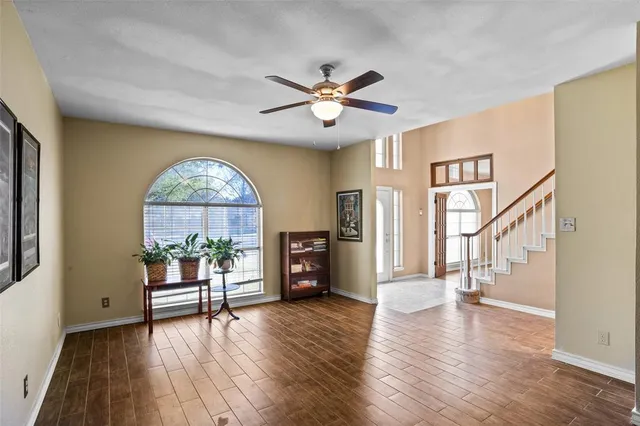 a view of empty room with wooden floor and fan