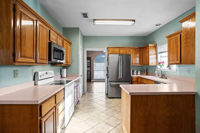 a kitchen with stainless steel appliances granite countertop a sink stove microwave refrigerator and cabinets