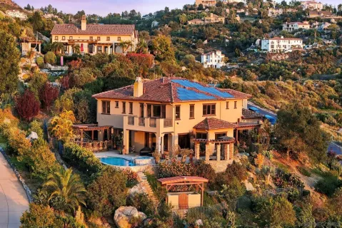 an aerial view of residential houses with outdoor space and trees