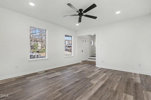 wooden floor fireplace and windows in an empty room