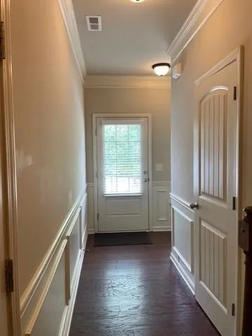 a view of hallway with wooden floor and fan