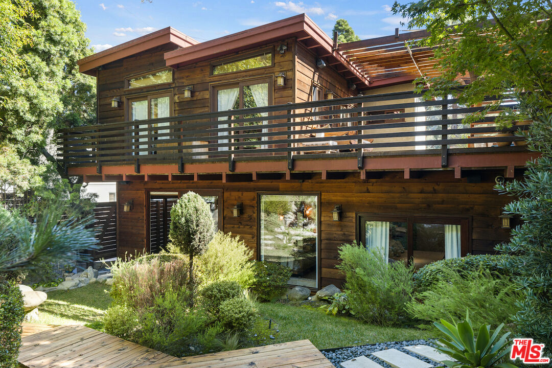 front view of house with a yard and potted plants