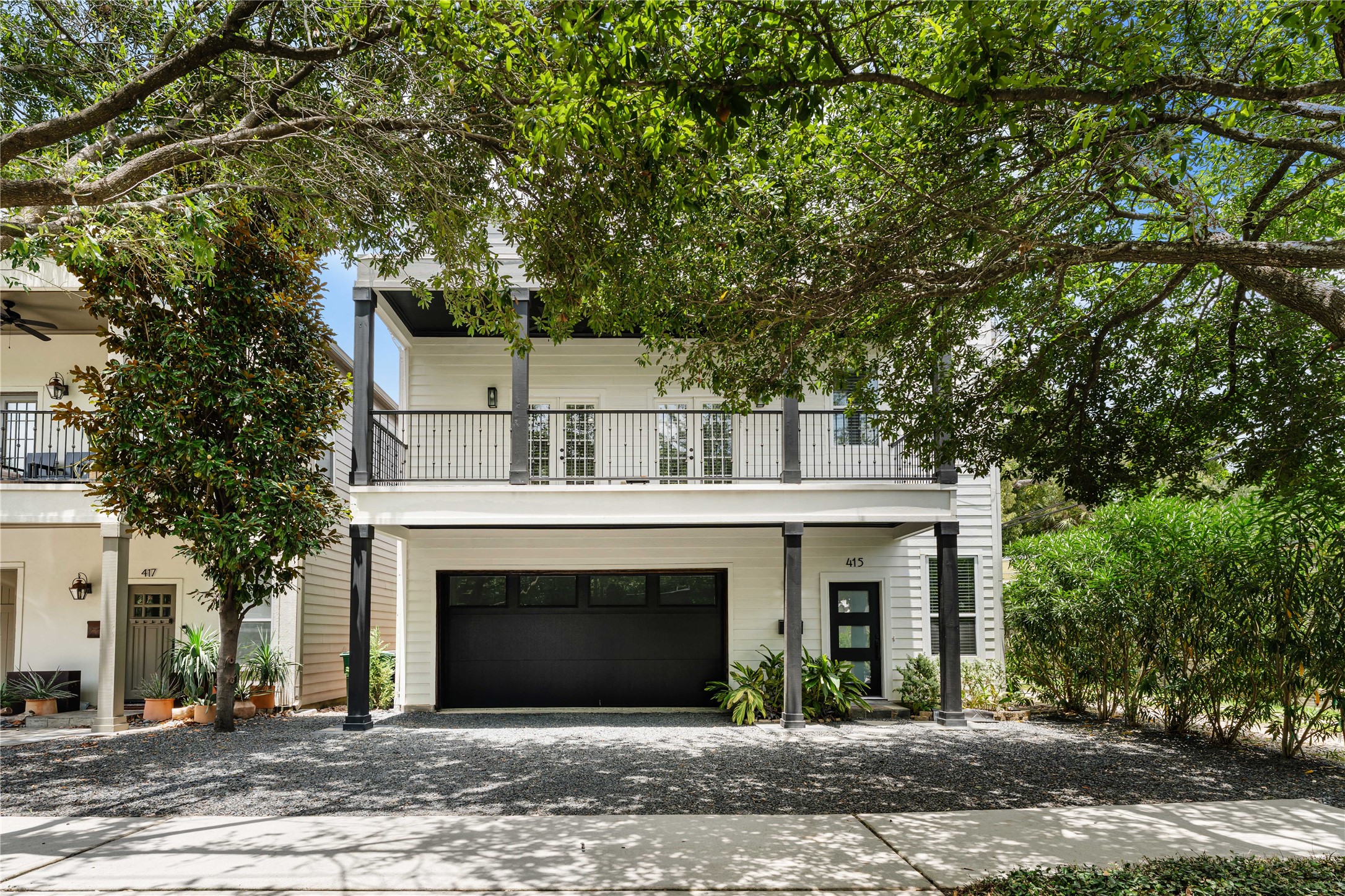 415 West 8th Street Houston, TX 77007 - Photo 4 of 39 The clean, contemporary exterior is highlighted by contrasting black columns and garage door, expansive covered balcony, and lush mature landscaping, creating a sophisticated look that stands out while fitting perfectly into the neighborhood.