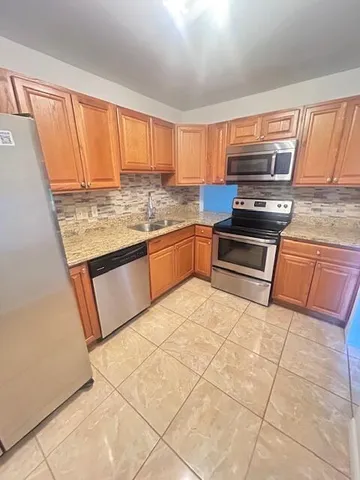 a kitchen with stainless steel appliances granite countertop a stove a sink and a microwave