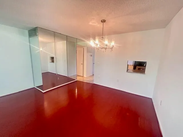 a view of an empty room with a chandelier fan