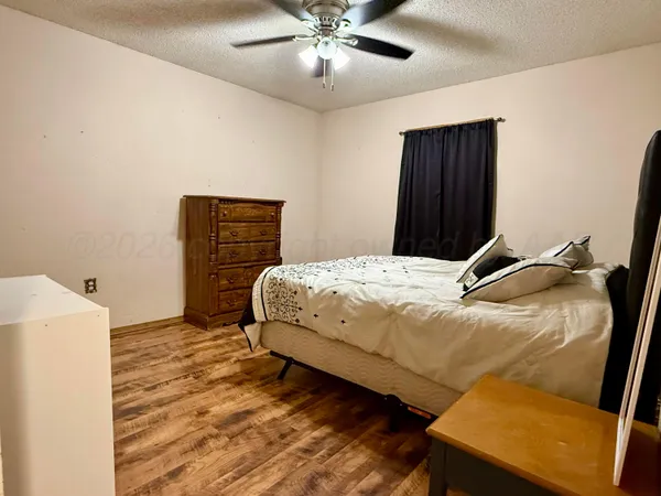 a bedroom with a bed and a refrigerator