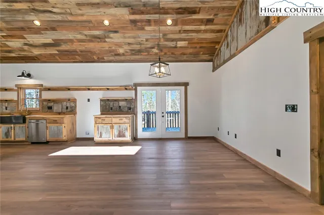 a bedroom with a large bed chandelier and a window