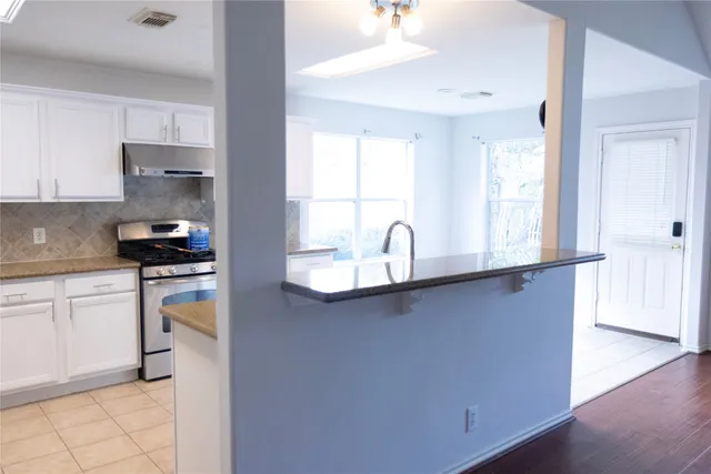 a kitchen with a sink a stove and cabinets