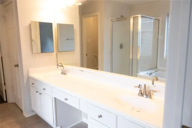a bathroom with a double vanity sink and mirror