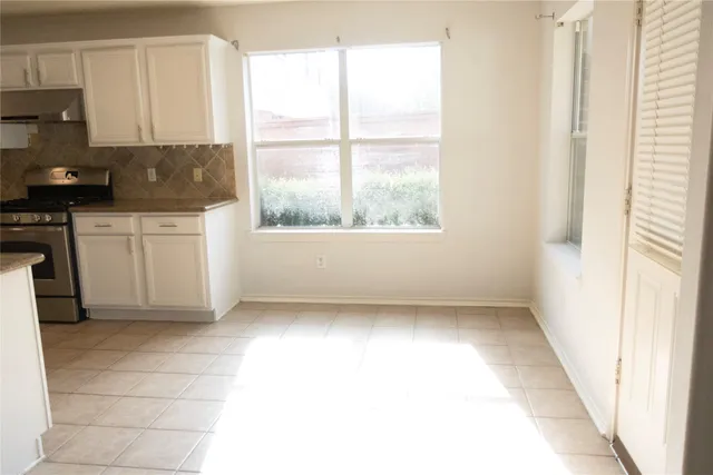 a kitchen with a white cabinets and window