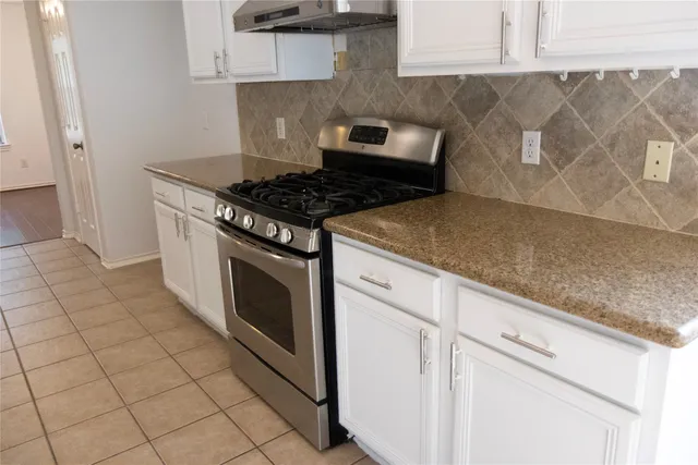 a stove top oven sitting inside of a kitchen