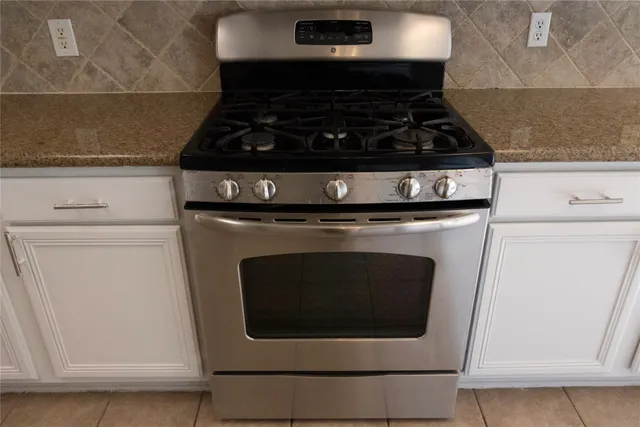 a stove top oven sitting inside of a kitchen