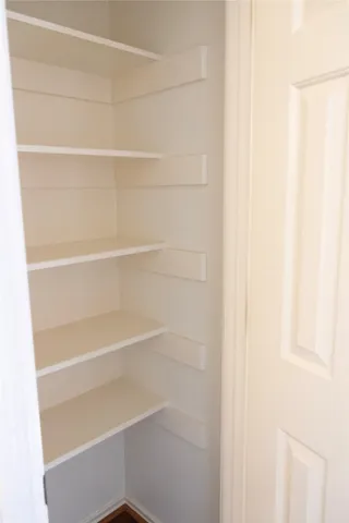 a view of walk in closet with empty racks