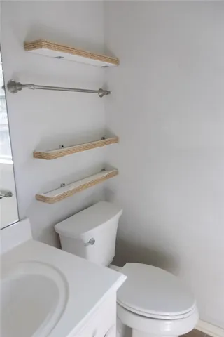 a white toilet sitting next to a bathroom sink