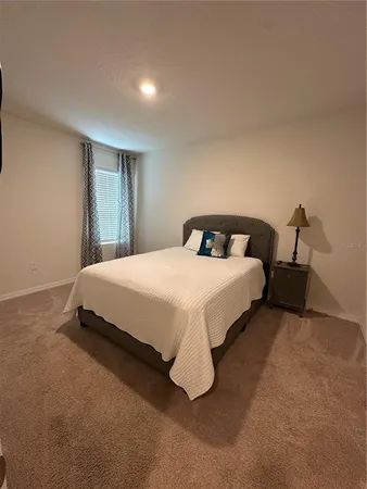 a bedroom with a bed and a night stand