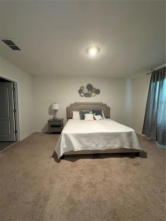 a bedroom with a bed and a lamp