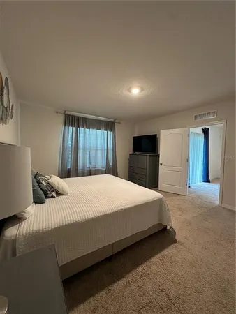 a bedroom with a large bed and a chandelier