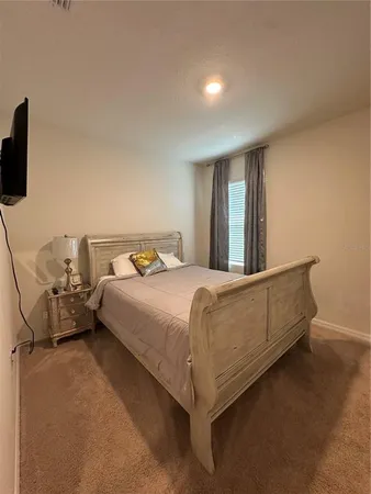 a bed sitting in a spacious bedroom next to a window