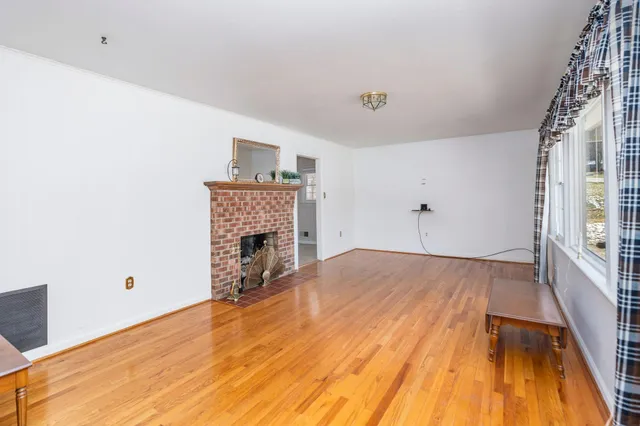 a view of empty room with wooden floor and fireplace