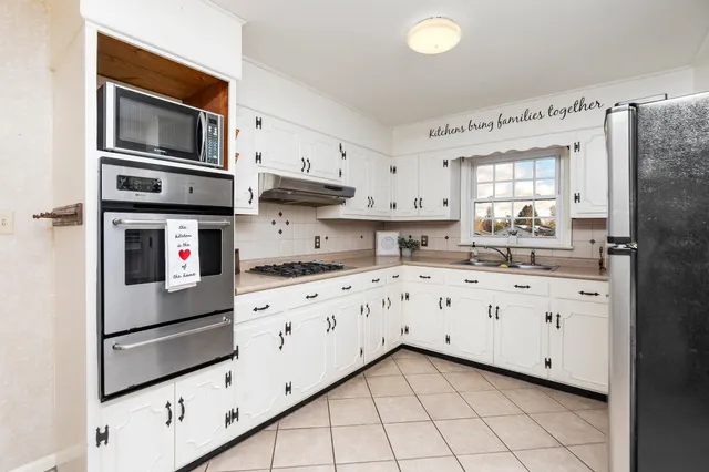 a bathroom with a granite countertop sink and washing machine