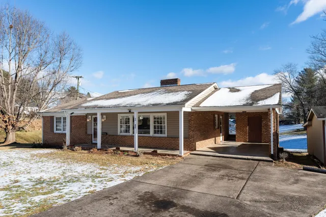 a view of a house with a yard covered with snow in the background