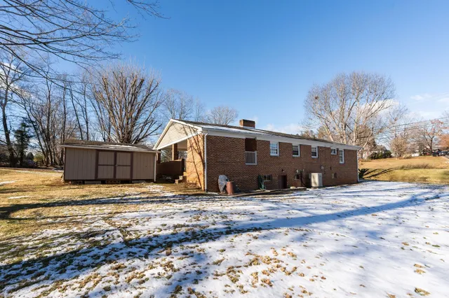a view of a house with a yard covered in snow