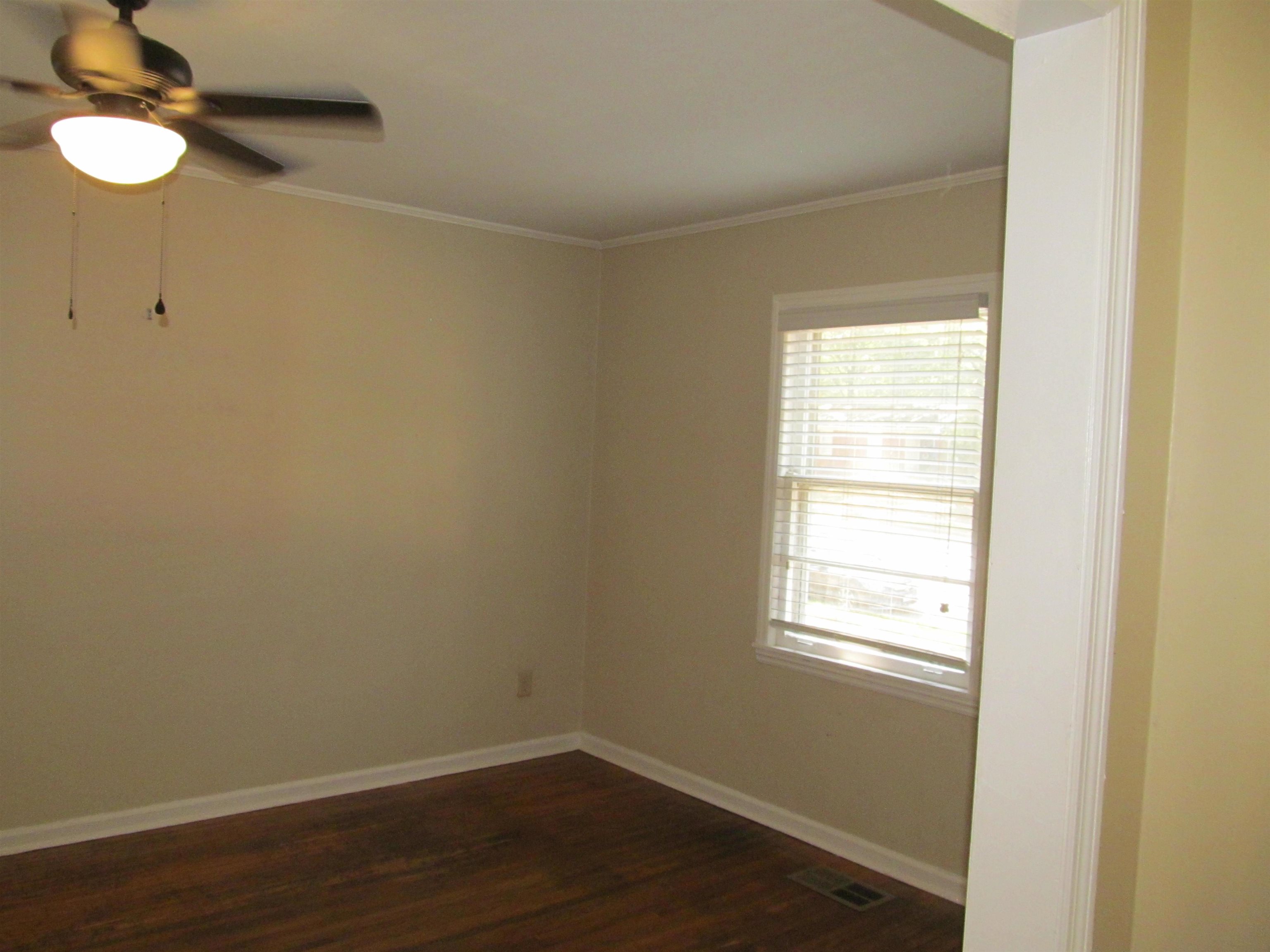 1022 South White Station Road Memphis, TN 38117 - Photo 3 of 14 a view of an empty room with wooden floor and a window