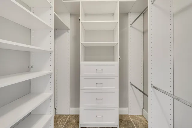 a view of walk in closet with empty racks