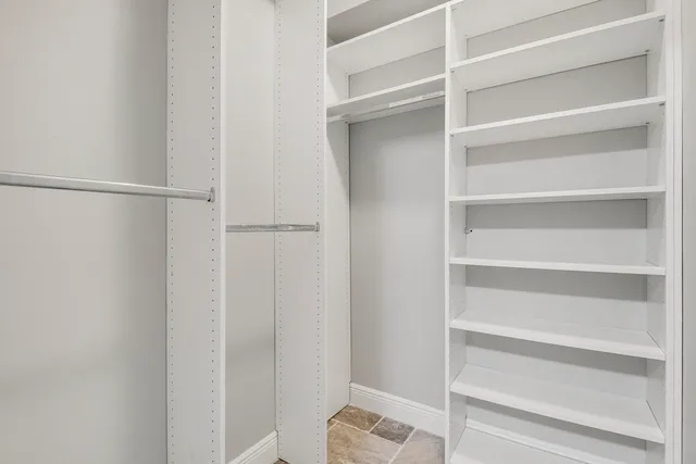 a view of walk in closet with empty racks