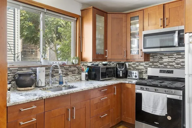 a kitchen with granite countertop a sink and a stove