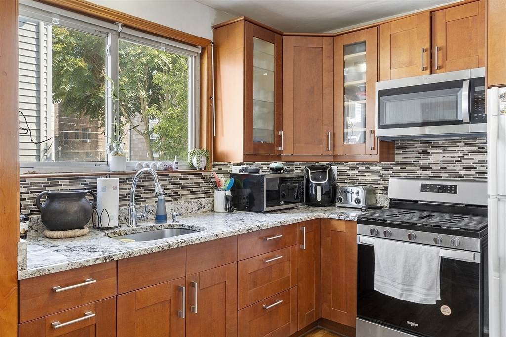 483 Broadway, Unit 1 Medford, MA 02155 - Photo 1 of 13 a kitchen with granite countertop a sink and a stove