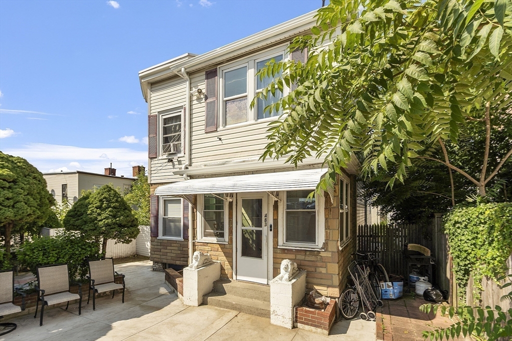 483 Broadway, Unit 1 Medford, MA 02155 - Photo 11 of 13 a view of a house with backyard sitting area and porch