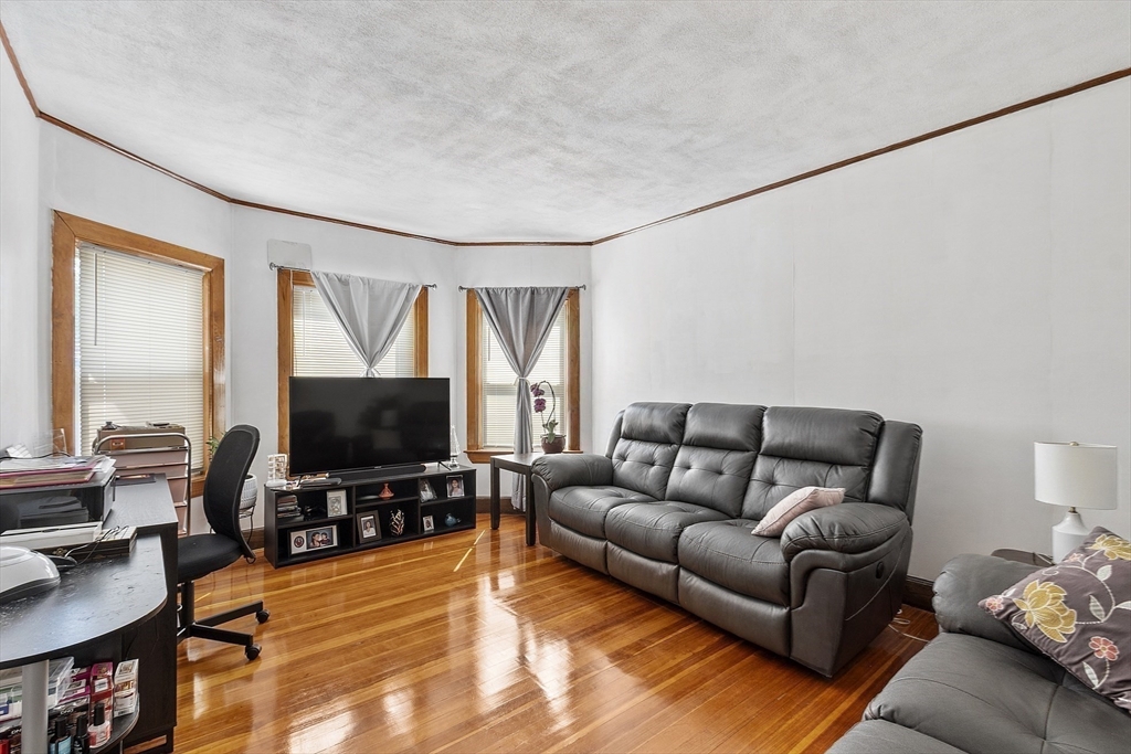 483 Broadway, Unit 1 Medford, MA 02155 - Photo 4 of 13 a living room with furniture and a flat screen tv