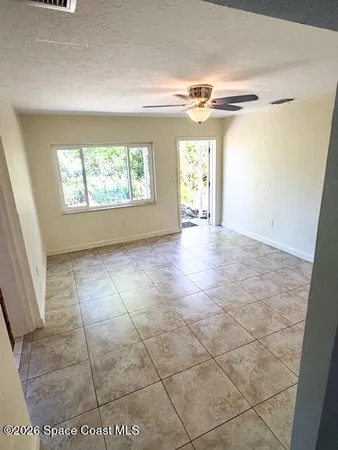a view of a livingroom with a window and a ceiling fan